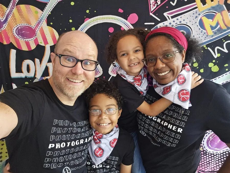 Tiana and Thomas with their two children, the family behind Open Circuit, in matching photography shirts